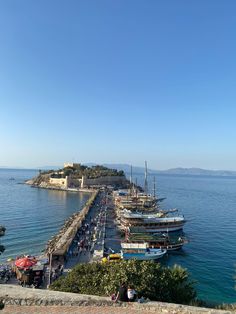 several boats are docked in the water next to an island