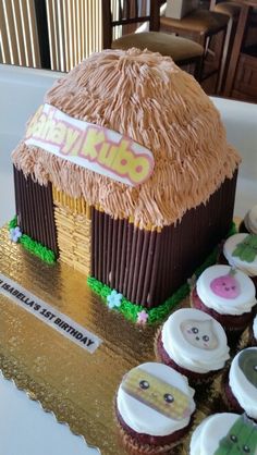 cupcakes are arranged in the shape of a small hut with grass on top