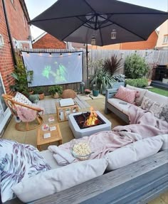 an outdoor patio with couches, chairs and a fire pit in the middle of it