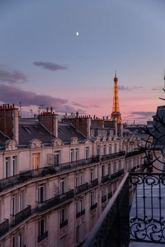 the eiffel tower towering over paris at dusk from an apartment building in france