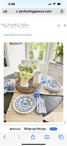 a table with plates and place settings on it, next to a basket filled with flowers