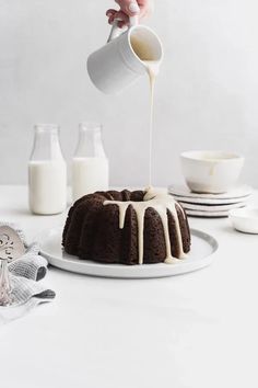 someone pouring milk over a bundt cake on a plate