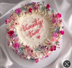 there is a white cake with pink and blue flowers on it that says twenty two