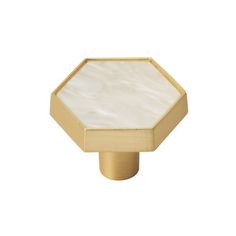 an octagonal brass knob with white mother of pearl inlay on the front and sides