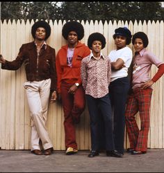 the jacksons posing for a photo in front of a fence