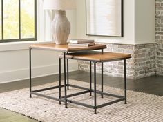 two end tables sitting on top of a rug in front of a brick wall and window