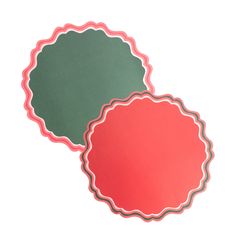 two red and green paper plates on a white surface with scalloped edges in the center