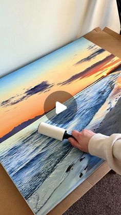 a person is painting a sunset on the beach