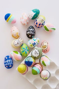 an assortment of painted easter eggs on a plate