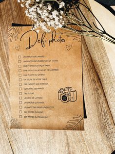 a wooden table topped with flowers and a brown paper sign that says delf photos