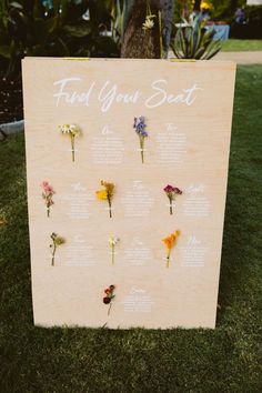 a wooden sign with flowers on it that says find your seat at the end of the ceremony