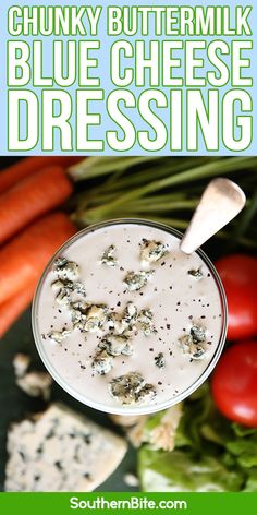 a bowl of blue cheese dressing with carrots and celery in the background