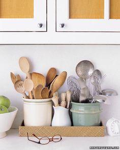 kitchen utensils and spoons are sitting on the counter