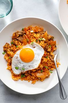 an egg on top of rice in a white bowl