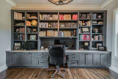 a home office with built in bookshelves and desk