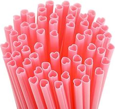 pink straws with hearts on them are lined up in a pile, against a white background