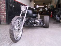 a black motorcycle parked in front of a garage with lots of tires and rims