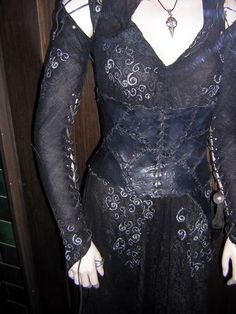 a mannequin dressed in black and white with long sleeves on it's chest