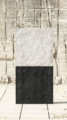 a black and white sculpture sitting on top of a wooden floor next to a wall