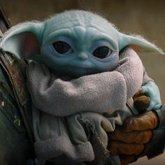 the baby yoda is holding onto a handbag that says, i got my good looks from mando