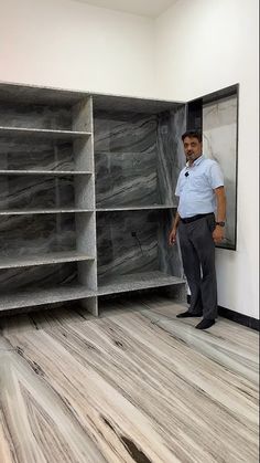 a man is standing in front of some shelves