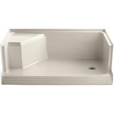 a white bath tub sitting on top of a white counter next to a shower head