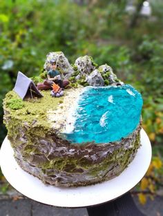 a cake that is sitting on top of a white plate with blue and green frosting