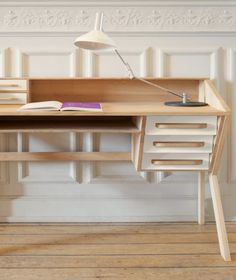 a wooden desk with two drawers and a lamp