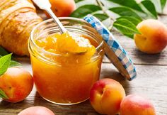 apricot sauce in a glass jar surrounded by peaches