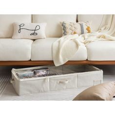 a white couch sitting next to a wooden table with a blanket on top of it