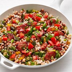 a white bowl filled with beans, tomatoes and other veggies on top of a table