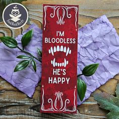 a red bookmark with the words i'm bloodless he's happy on it