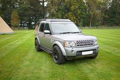 a silver land rover is parked in the grass