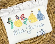 this is an embroidered towel with princesses on it and the name ella james as