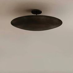 an overhead light fixture in a room with white walls and flooring on the side