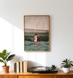 a record player sitting on top of a wooden table next to a potted plant