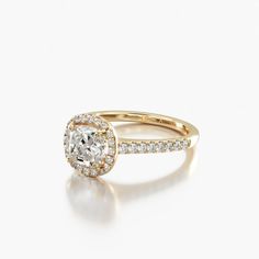 a yellow gold engagement ring with an oval cut diamond and pave set diamonds around the band