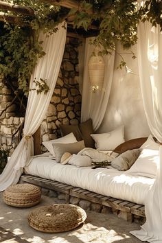 an outdoor bed with white drapes and pillows