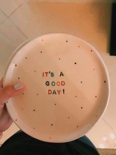 a person holding a plate with the words it's a good day written on it