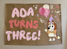 a brown paper bag with pink and white balloons on it that says aoa turns three