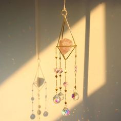 a wind chime hanging from the side of a wall with beads and crystals on it