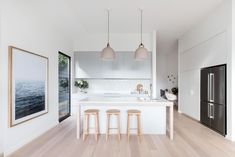 a kitchen with white walls and wooden floors