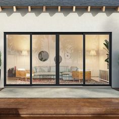 a living room with sliding glass doors and potted plants on the side of it