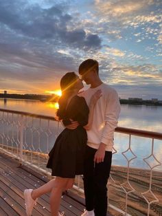 a man and woman standing next to each other on a pier