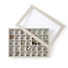 an open box containing several pairs of rings and ear studs, on a white background