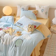 a bed with winnie the pooh comforter and pillow cases on top of it