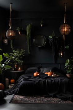 a dark bedroom with plants and candles on the bed