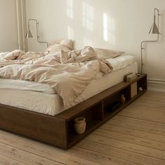 an unmade bed sitting on top of a wooden floor