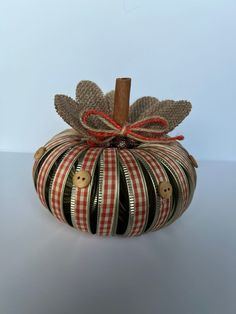 a striped pumpkin with a wooden stick sticking out of it's center and leaves on top