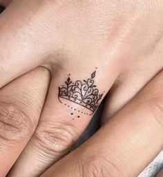 two people with tattoos on their fingers and one has a crown tattooed on the finger